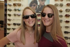 two women wearing sunglasses and smiling
